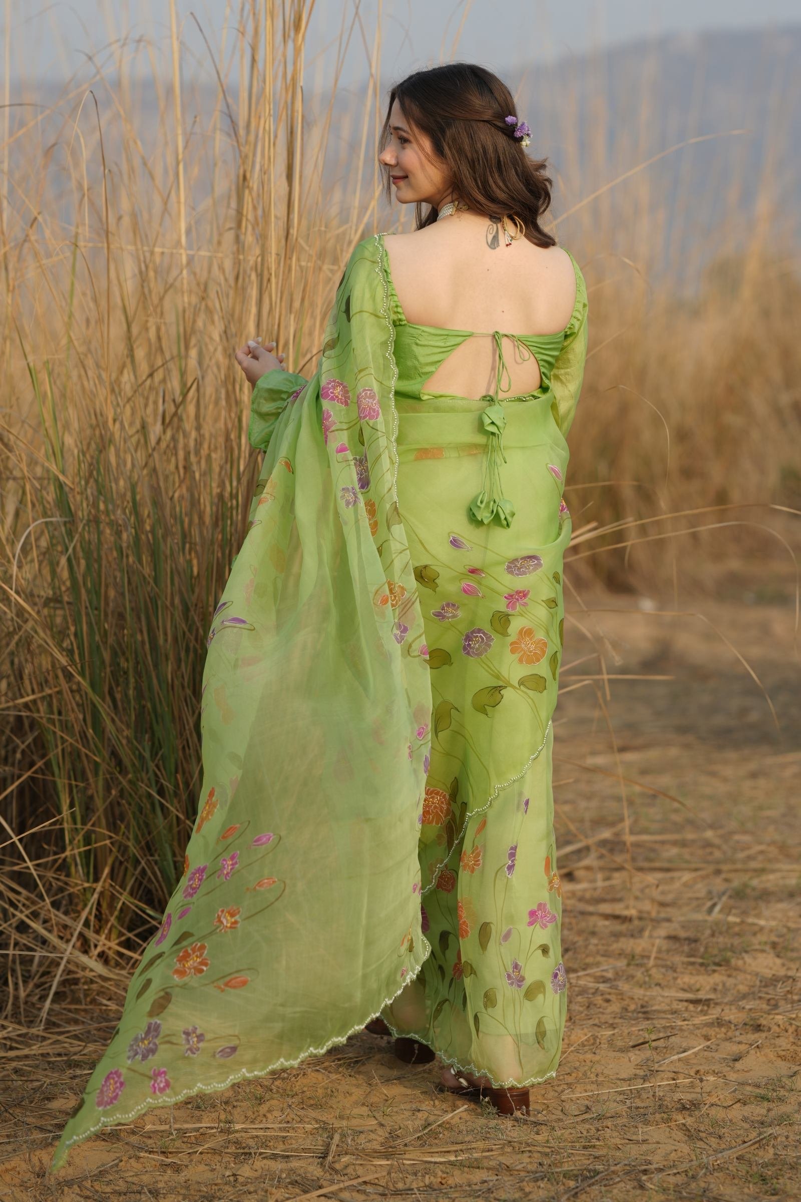 Back view of the Luxury Lime Green Organza Saree, featuring hand-embroidered Katdana and colorful handpainted poppies.
