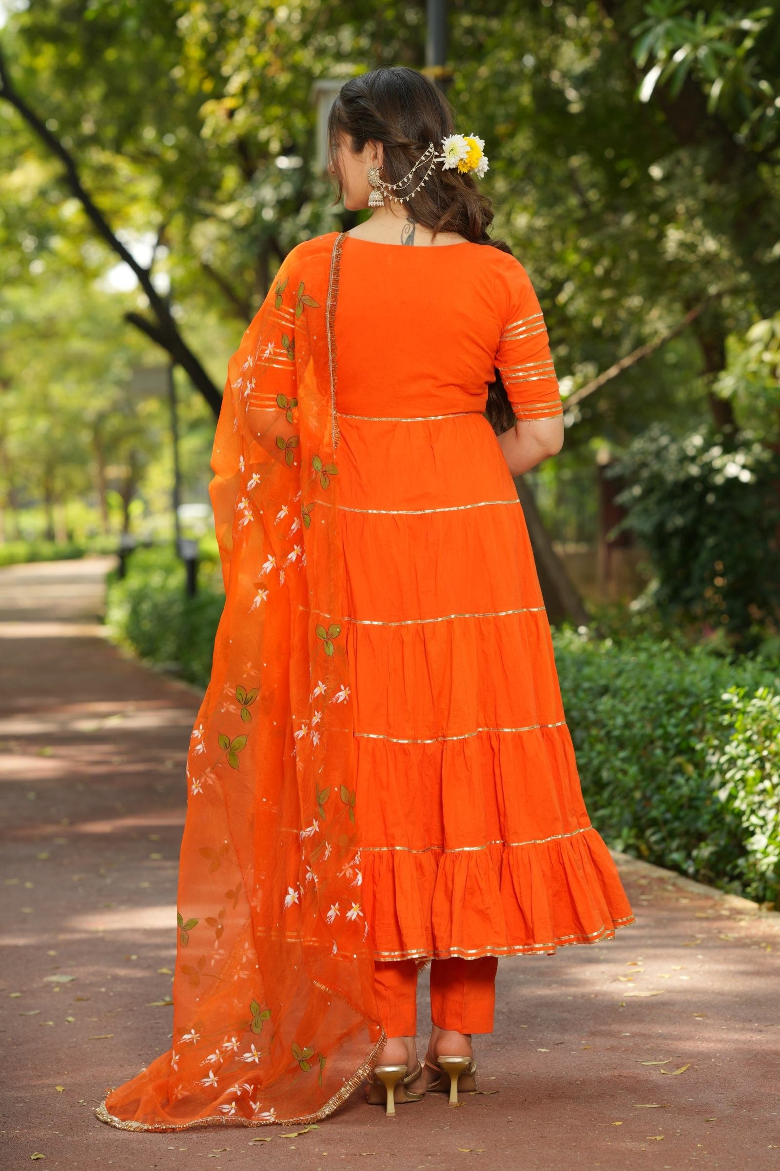 Back view of the vibrant orange Anarkali set, highlighting the dupatta's pure organza fabric and handpainted florals.