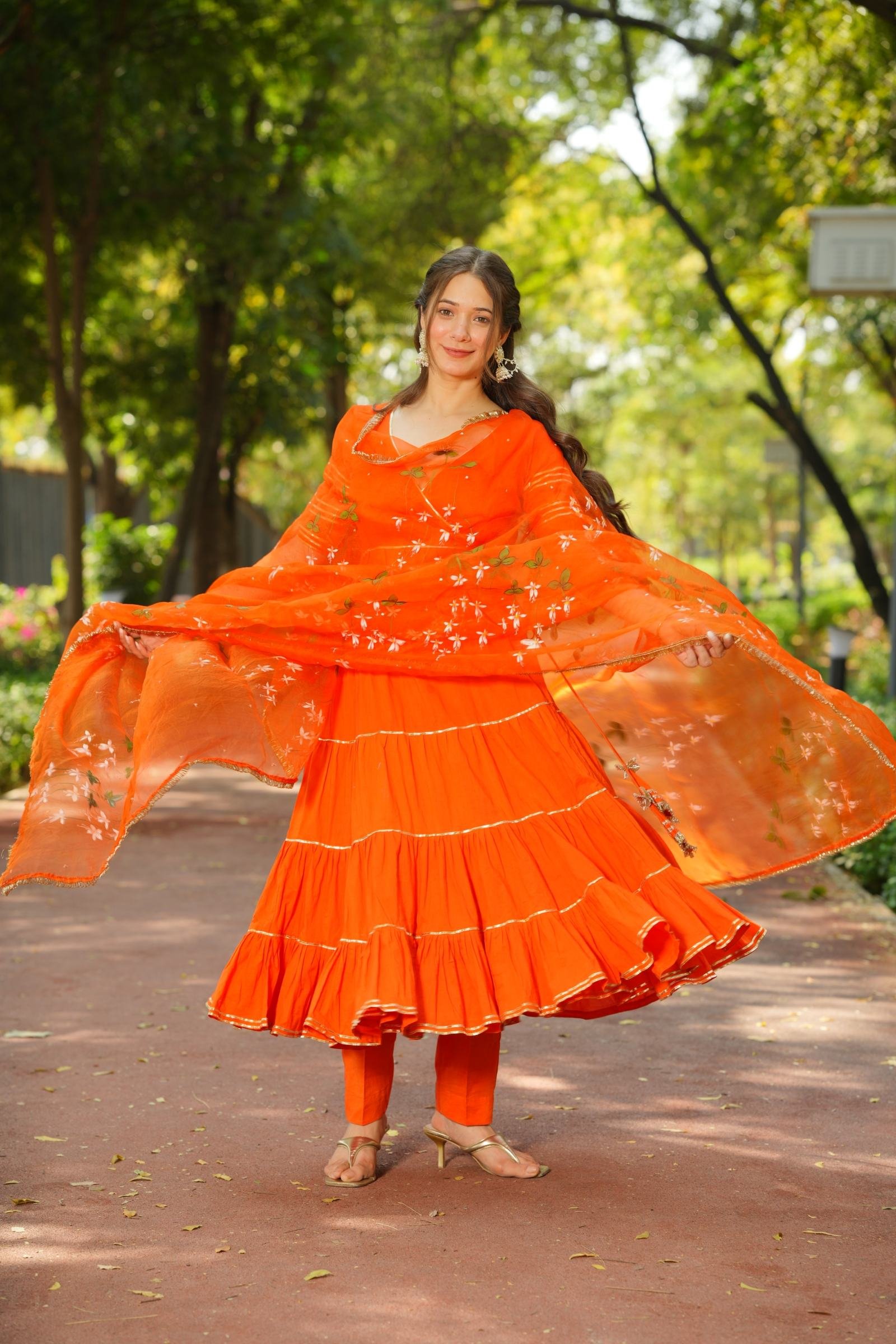 Close-up of the Gota Patti detailing on the orange Anarkali kurta and the floral handpainting on the organza dupatta.