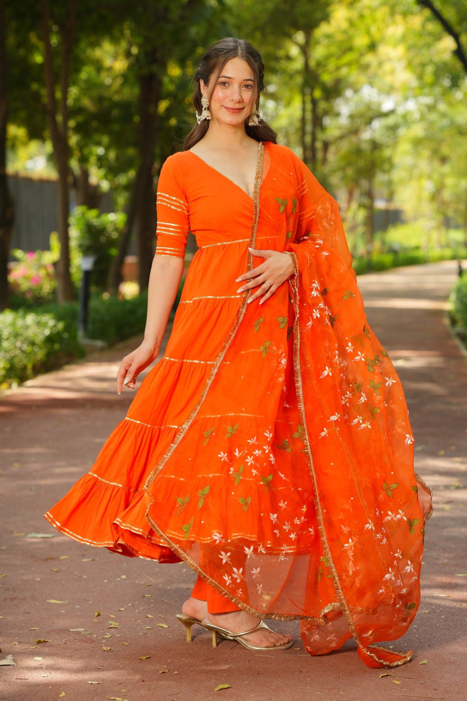 Side view of model twirling in Marigold Melody Anarkali, showcasing the flow of the tiered skirt and handpainted dupatta.
